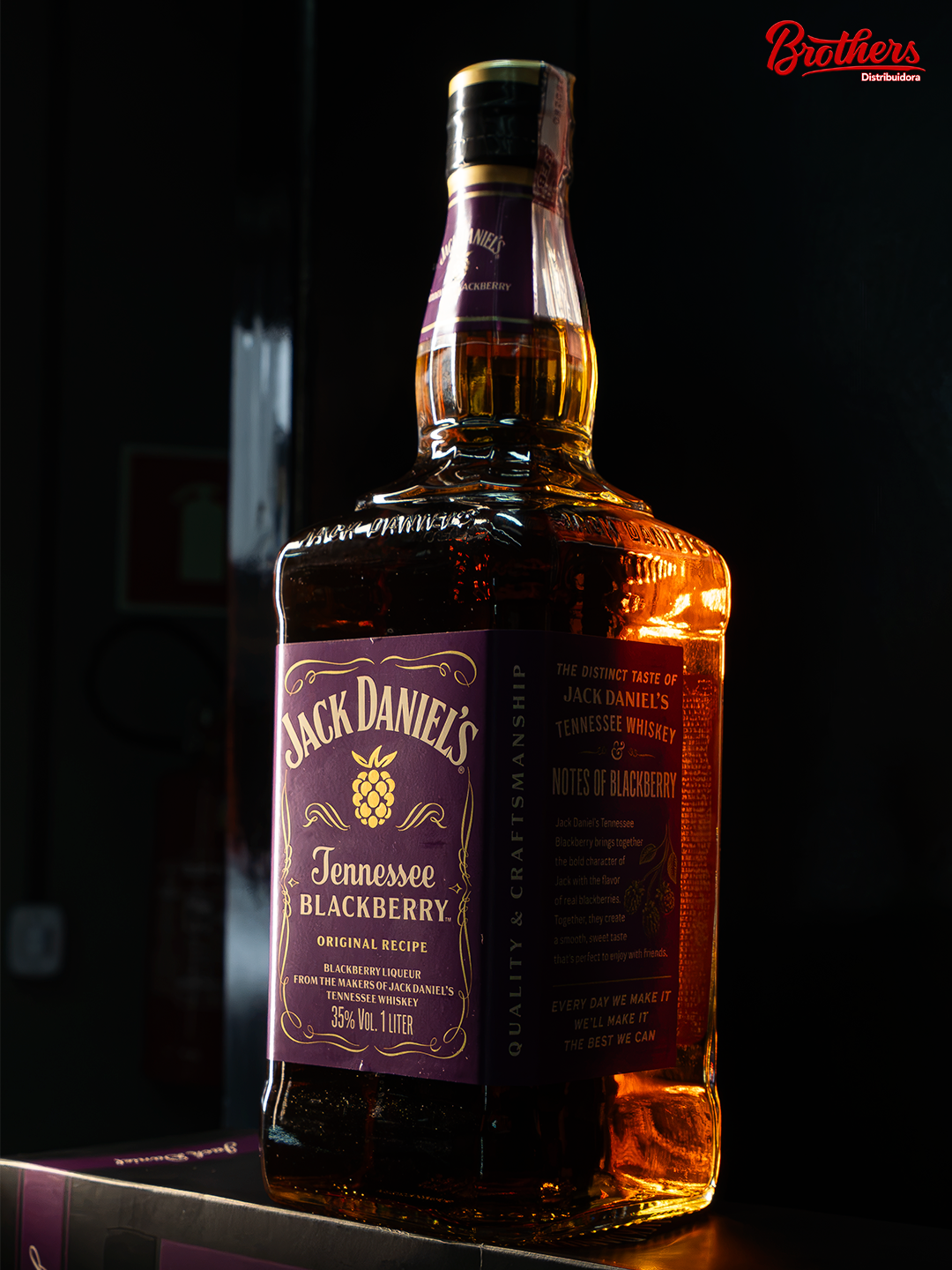Garrafa de whisky Jack Daniel's Blackberry iluminada em cena escura.